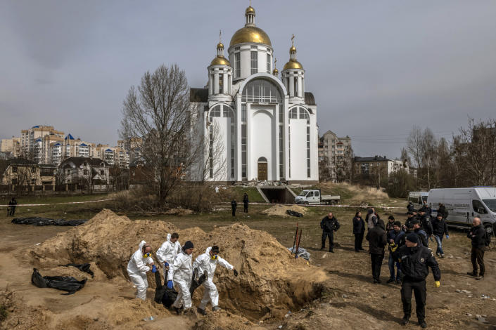 Bodies are exhumed from a communal grave near the Church of St. Andrew in Bucha, Ukraine, April 8, 2022. (Daniel Berehulak/The New York Times)