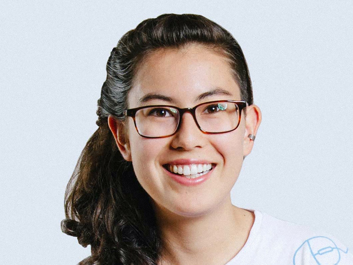 Headshot of Tess Rinearson against a light blue-grey background