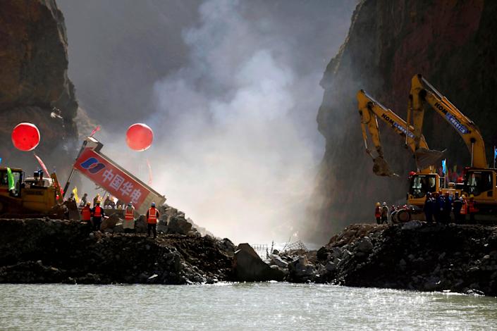 Trucks dump rocks to overcome river closure during construction of Lawa Hydropower Station on the headwaters of the Jinsha River on Nov. 29, 2021 in Garze Tibet Autonomous Prefecture, China's Sichuan Province.