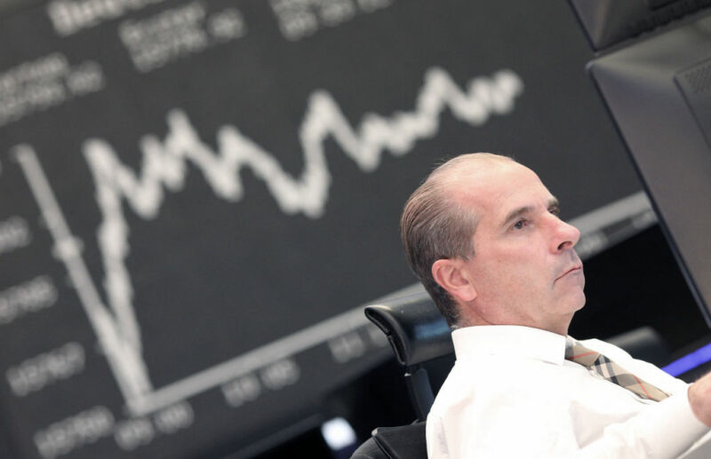 Image of a person in front of a chart tracking investment performance.