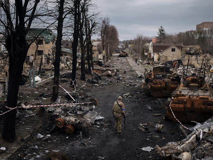 A Ukrainian soldier walks amid destroyed Russian tanks in Bucha, on the outskirts of Kiev, Ukraine, April 6, 2022.