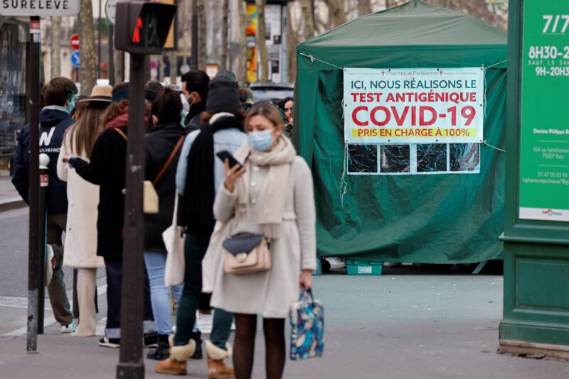 Members of the public queue in front of a pharmacy to undergo COVID-19 antigen testing in Paris on January 6, 2022.