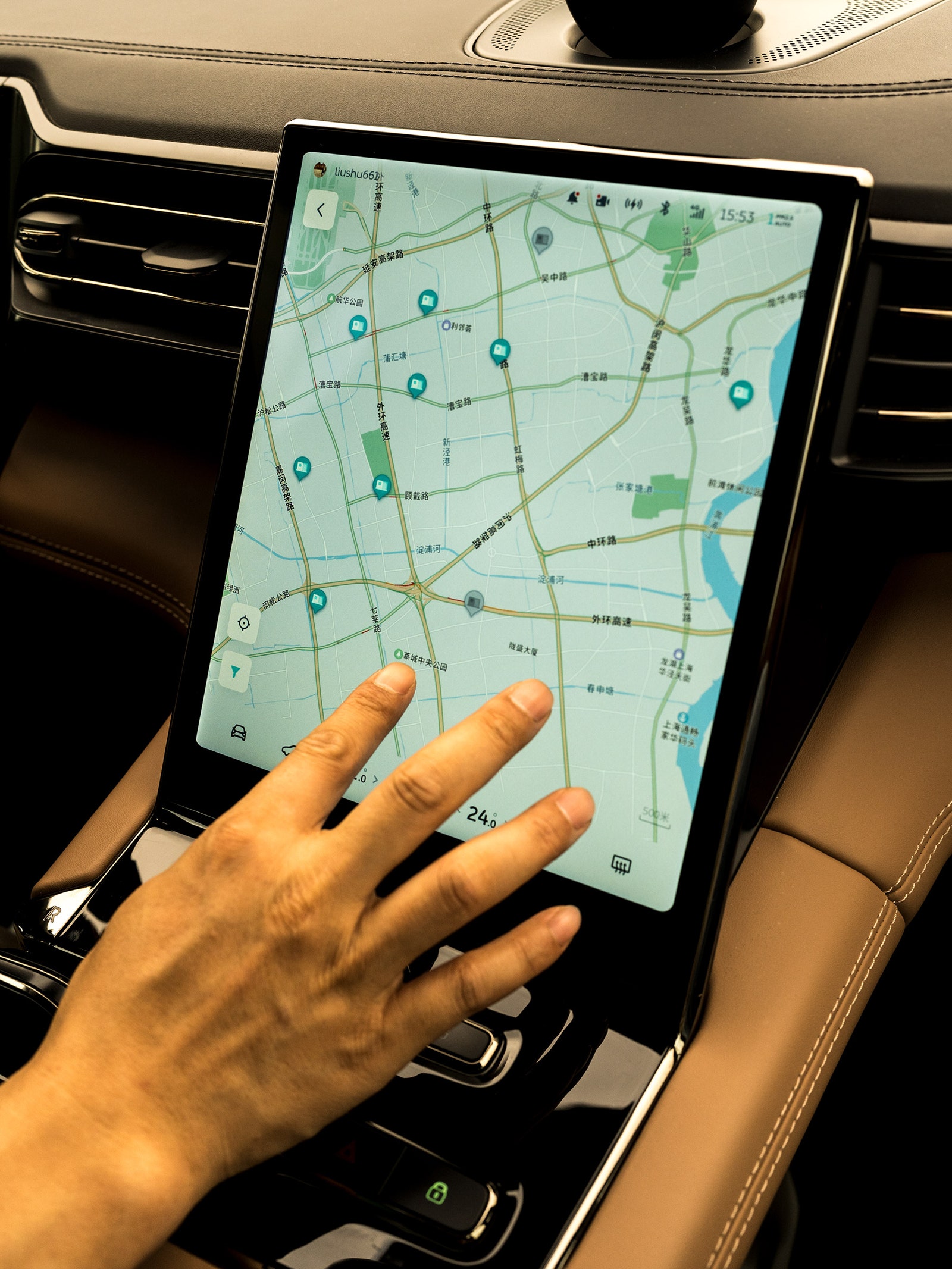 The hand of a person touching the map of NIO battery change stations on a touch screen dashboard in electric vehicle