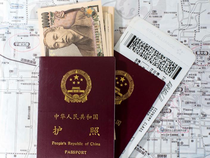 Chinese passport, Japanese Yen and airline tickets arranged for photography.