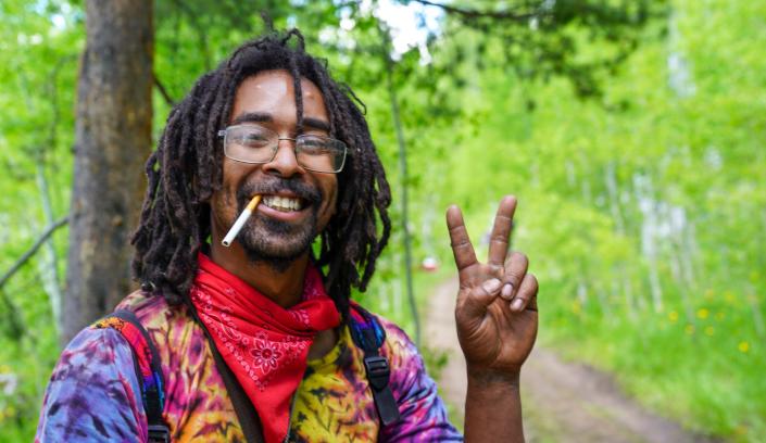 Erik Childress, 30, of Oregon flashes a peace sign as he takes a break from hiking to the Rainbow Family gathering on June 26.