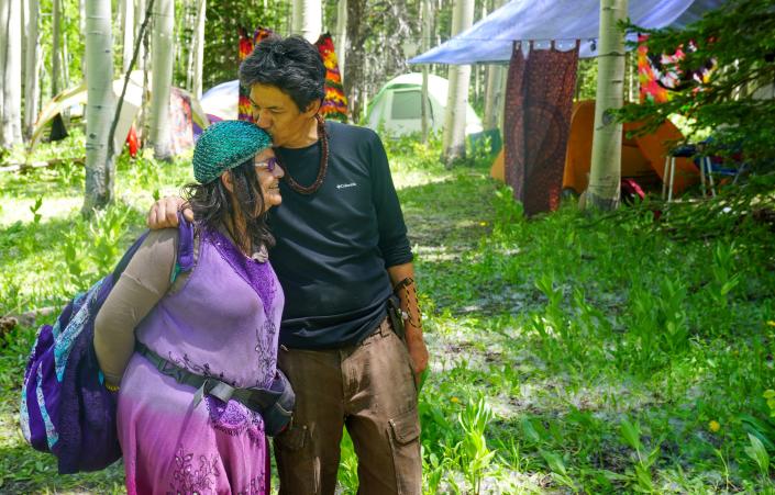 Rainbow Family attendees hug at the reunion as they prepare for this year's annual camp, held in a remote part of Colorado's Routt National Forest on June 26.