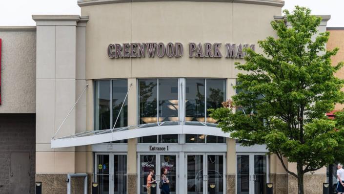 A group of people wait outside an entrance to Greenwood Park Mall on July 18, 2022