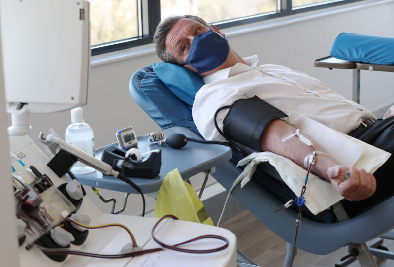 A plasma donor is connected to an apheresis machine, which separates plasma from blood when people donate blood plasma for medicine, at the Twickenham Donor Centre, south west London on 7 April 2021. 