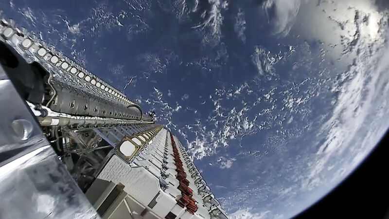 A stack of 60 Starlink satellites are launched into space, with Earth in the background.