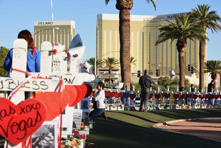 In this October 2017 photo, just days after the mass shooting in Las Vegas, a woman prays next to 58 white crosses lined up in honor of the victims who died when a gunman opened fire from the 32nd floor of the Mandalay Bay hotel.