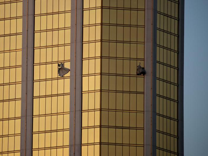 In this file photo from Monday, October 2, 2017, curtains blow from broken windows at the Mandalay Bay resort and casino on the Las Vegas Strip, following a mass shooting at a Las Vegas music festival.