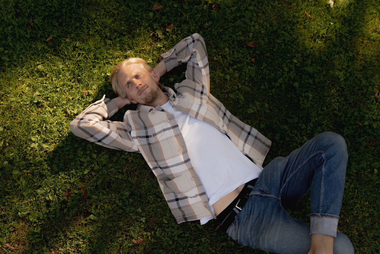 Rickard Zilliacus one of the three co-founders of second-hand furniture platform Mjuk lying in the grass.