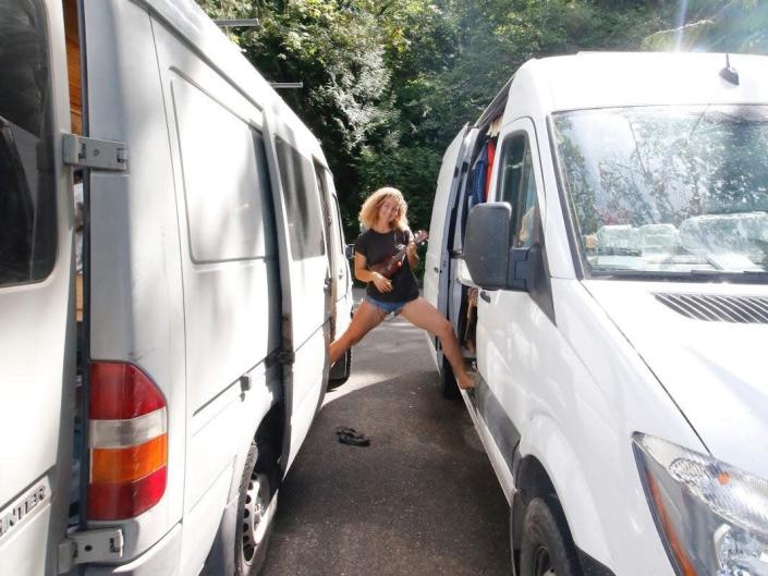 Kaya Lindsay stands between two vans