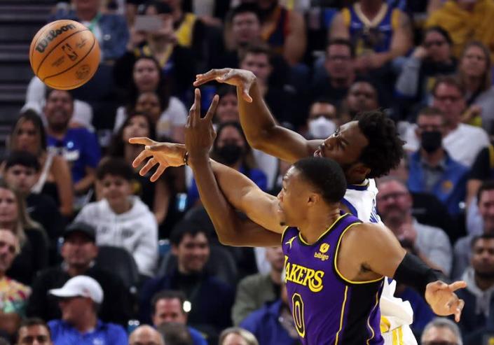 SAN FRANCISCO, CALIFORNI - OCTOBER 18: Andrew Wiggins #22 of the Golden State Warriors and Russell Westbrook #0 of the Los Angeles Lakers compete for the ball during the 1st half of game at Chase Center on October 18, 2022 in San Francisco, California .  NOTE TO USER: User expressly acknowledges and agrees that by downloading and/or using this photo, User agrees to the terms of the Getty Images License Agreement.  (Photo by Ezra Shaw/Getty Images)