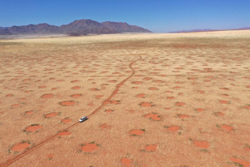 Drone image of a car driving through the NamibRand Nature Reserve, one of Namibia's fairytale regions.