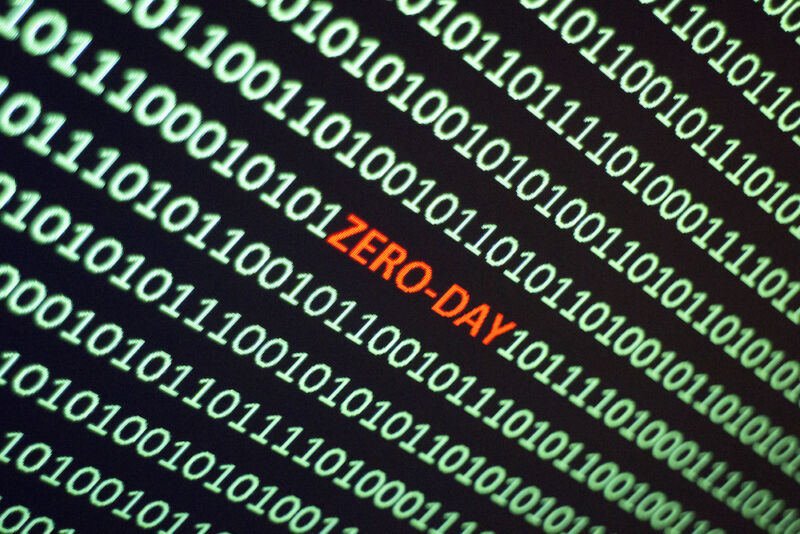 The word ZERO-DAY is hidden in a screen full of ones and zeros.