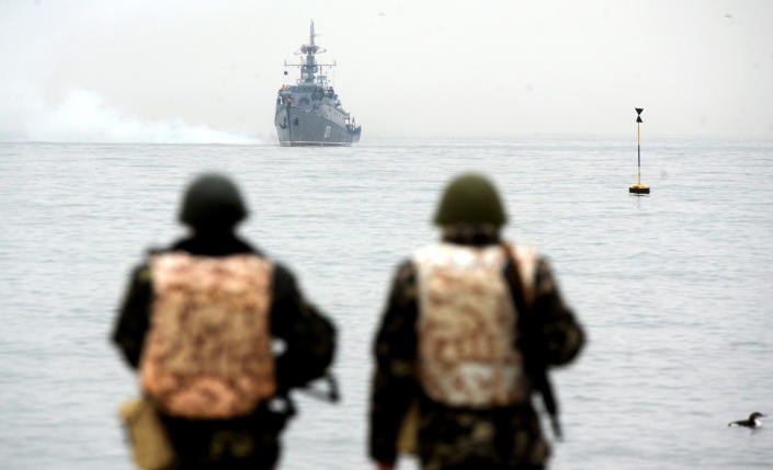 Ukrainian marines watch a Russian ship drifting out of Sevastopol Bay on March 4, 2014.  The Russian commander of the Black Sea Fleet, Aleksandr Vitko, has issued an ultimatum to the Ukrainian army in Crimea, the Interfax-Ukraine news agency reported.  Ukraine accused Russia of pouring more troops into Crimea on March 3 as world leaders grappled with Europe's worst standoff since the Cold War and the Moscow market collapsed amid fears of an all-out conflict.  AFP PHOTO/ VIKTOR DRACHEV (Photo credit must read VIKTOR DRACHEV/AFP via Getty Images)