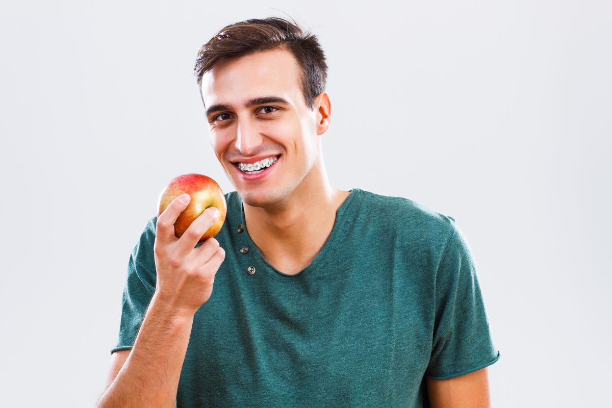 Man with braces and whole apple