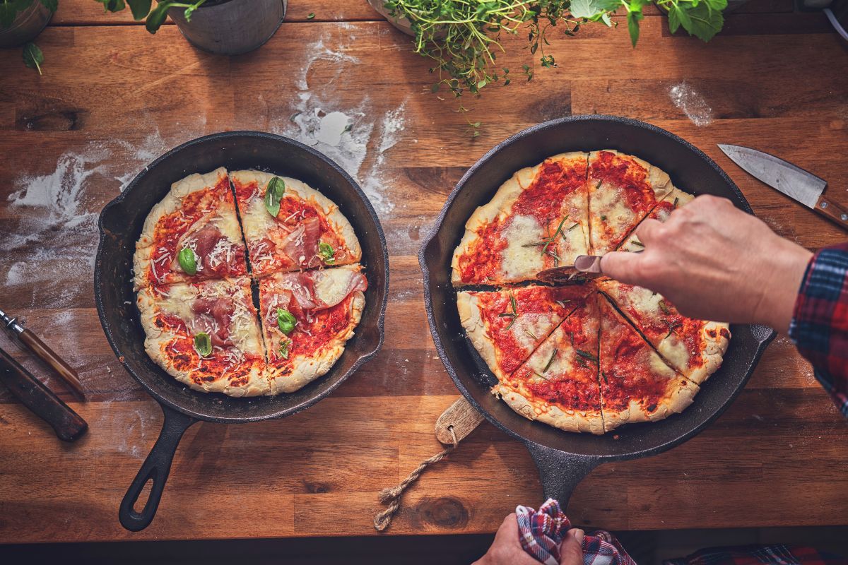 Pan pizzas are sliced ​​on the kitchen table