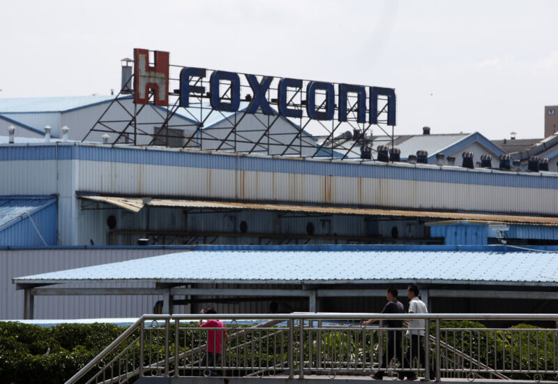 Workers walk outside Hon Hai Group's Foxconn factory in Shenzhen, China, in 2010.