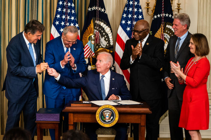 President Biden, seen presenting a pen to Senator Joe Manchin, with Senator Chuck Schumer and Representatives James Clyburn, Frank Pallone and Kathy Castor at the White House.