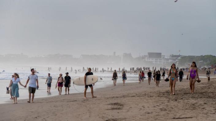 BALI, INDONESIA - 9/17/2022: Large crowds of tourists and expats are seen at Seminyak Beach.  Indonesia tourism is picking up after the covid 19 pandemic.