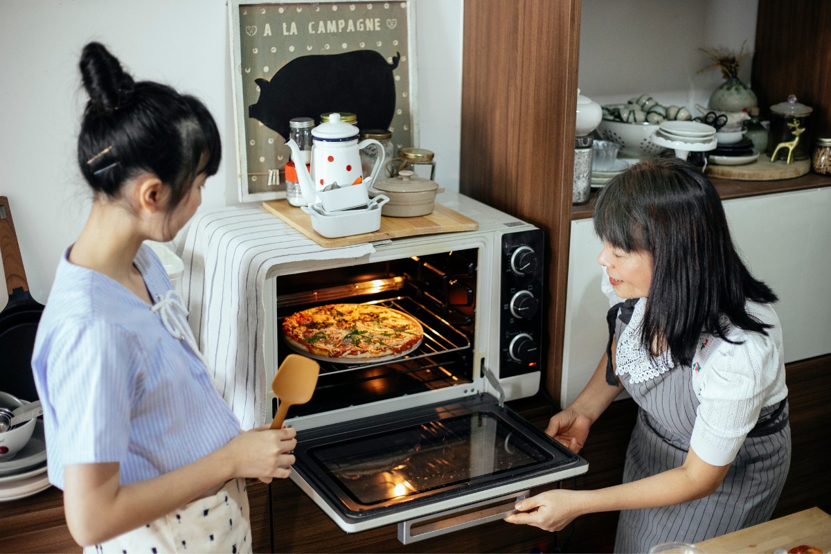 Harvest women putting pizza in the oven