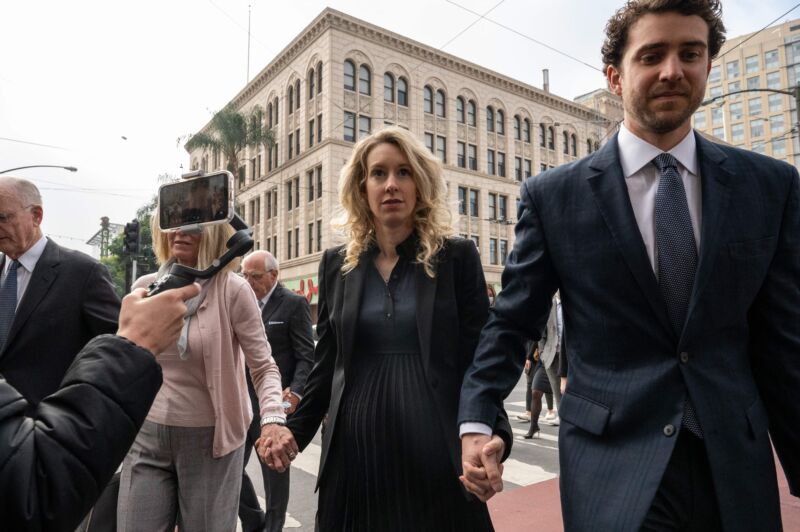 Elizabeth Holmes (C), founder and former CEO of blood testing and life sciences company Theranos, walks into the federal courthouse with her mother Noel Holmes and partner Billy Evans for her sentencing hearing on November 18, 2022 in San Jose, California. 