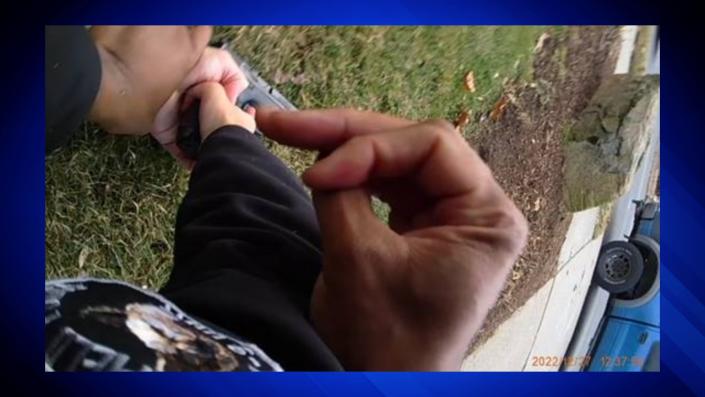 Photo from the Springfield Police Department's body-worn camera showing the suspect's hand on the handle of the firearm and his finger on the trigger.  Both officers try to disarm the suspect.