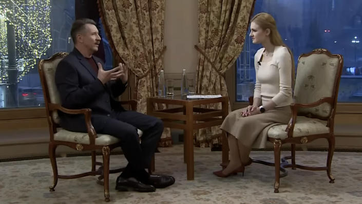 Viktor Bout and Marina Butina sit opposite each other during a television interview.