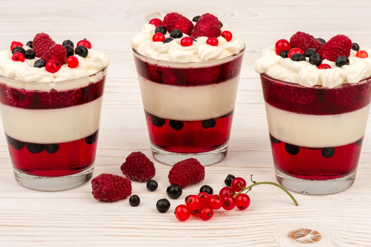 Yoghurt dessert with whipped cream, jelly, raspberries and blueberries.