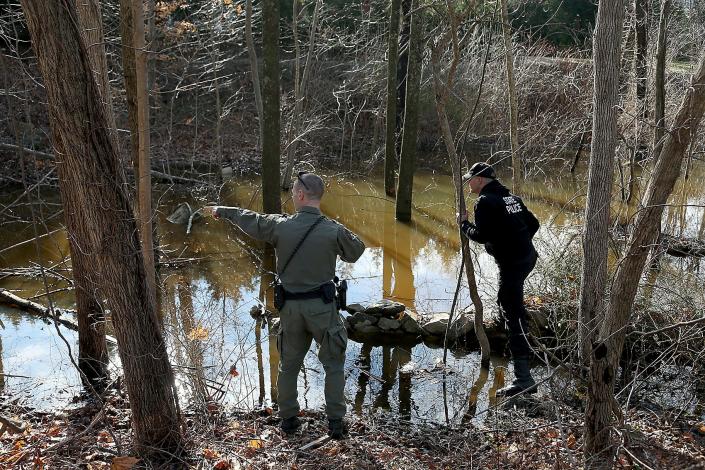 A Massachusetts environmental police officer points out something to a police officer during their search for Ana Walshe across the street from her home on Rt.  3A in Cohasset on Saturday, January 7, 2023. 