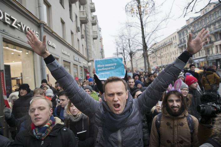 Alexei Navalny with arms raised among a crowd of people at a rally in Moscow.