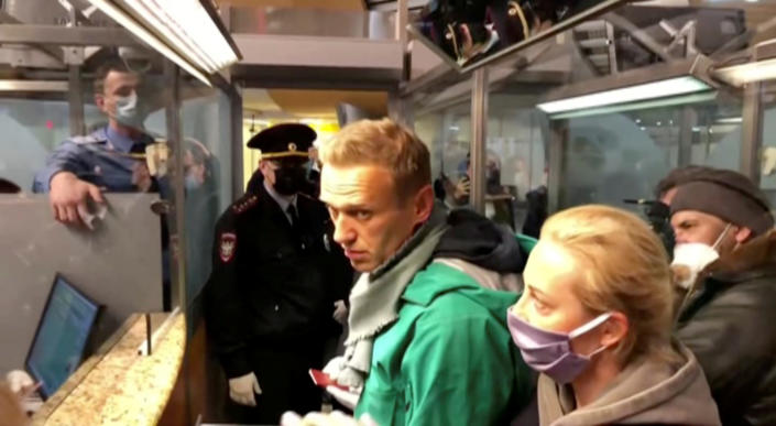 A still from video footage shows law enforcement officers speaking with Navalny at Moscow's Sheremetyevo airport.