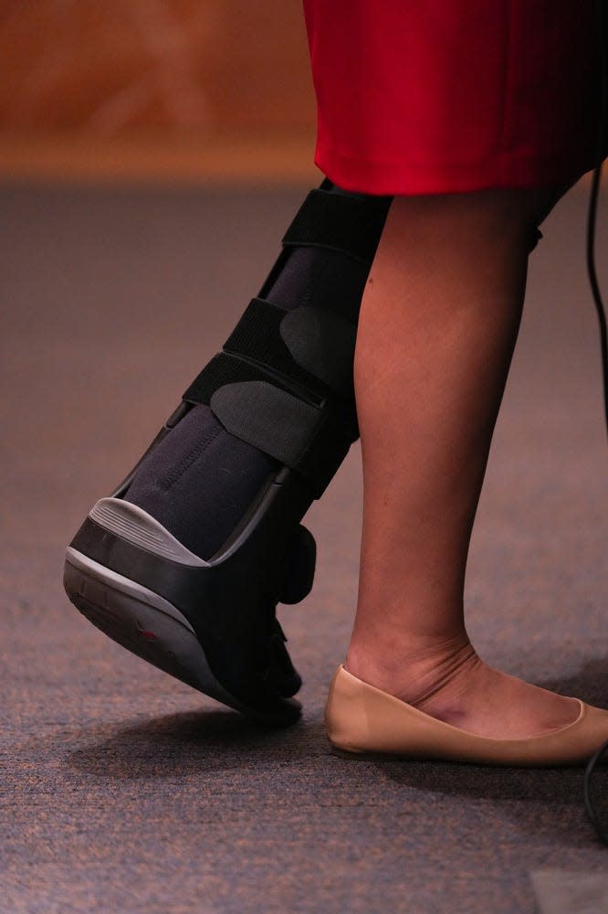 Gov. Katie Hobbs wears a hiking boot as she answers questions at a press conference at the Arizona State Capitol on Friday, Jan. 20, 2023 in Phoenix.