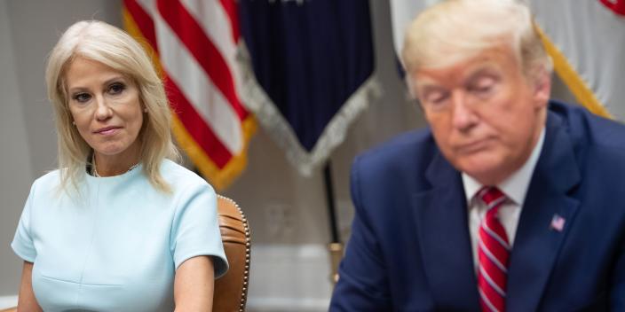 Kellyanne Conway and Donald Trump listen during a White House rally about the 2019 opioid epidemic.