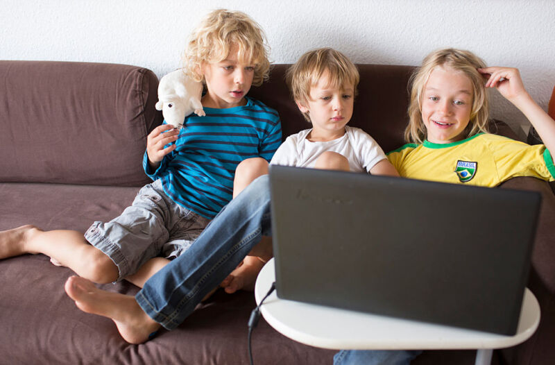 Children look at a laptop