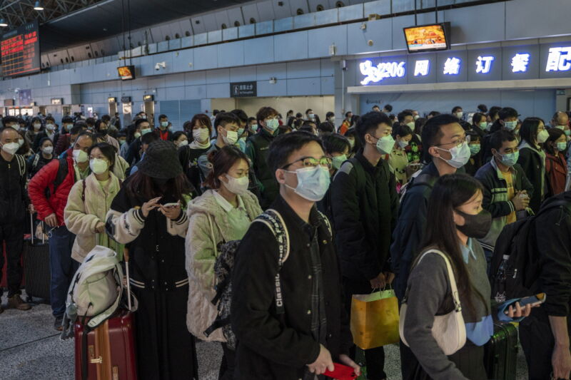 Passengers wearing face masks wait to board a high-speed train at Guangzhou South Railway Station in Guangzhou, China, on January 15, 2023.  China is currently experiencing the Spring Festival travel season, where millions of Chinese people travel across the country before celebrating the Chinese or Lunar New Year. 