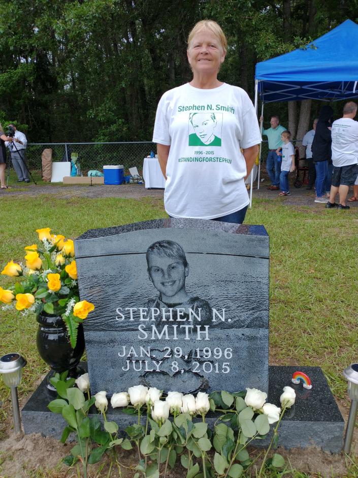 Sandy Smith smiles behind the new monument to her son, Stephen Smith.