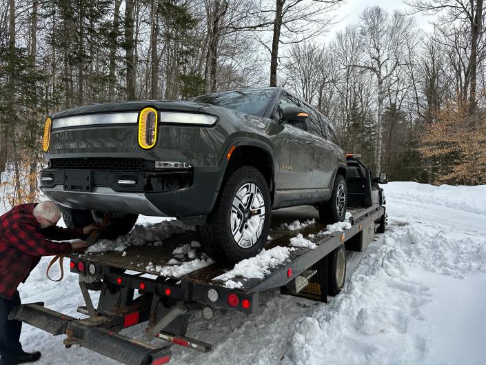 The disabled Rivian R1S is loaded onto a low-loader.