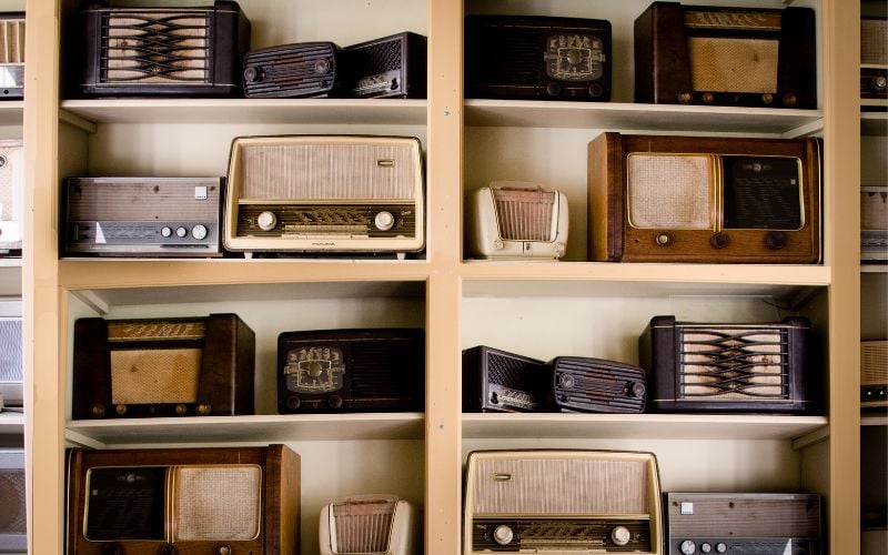 Wooden shelves filled with all sorts of vintage radio styles