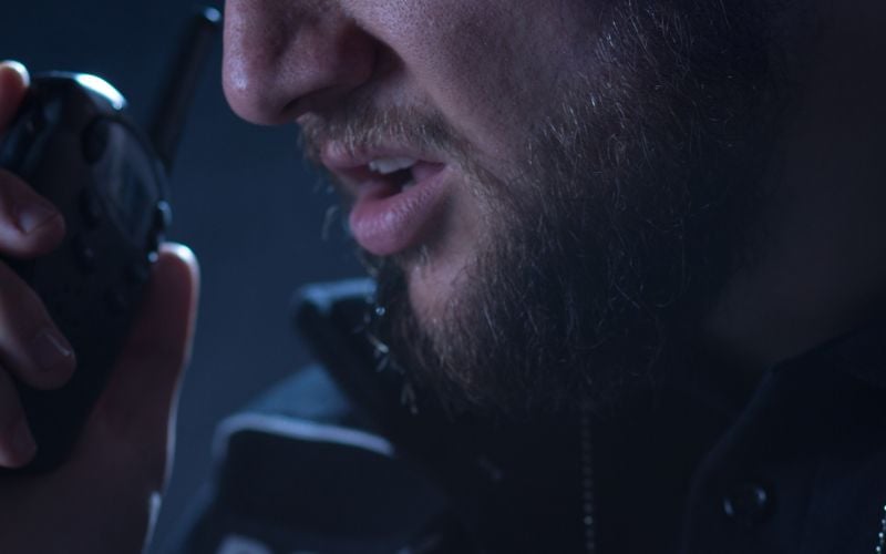 Close-up of a man speaking into a handheld radio