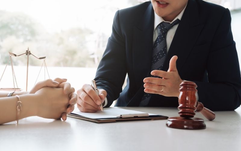 Lawyer in a black suit and blue tie speaking to a client