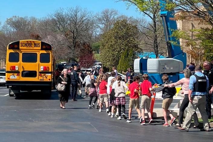 Children at The Covenant School, a private Christian school in Nashville, Tennessee, hold hands as they are taken to a reunion site at Woodmont Baptist Church on Monday, March 27, 2023 following a shooting at their school.