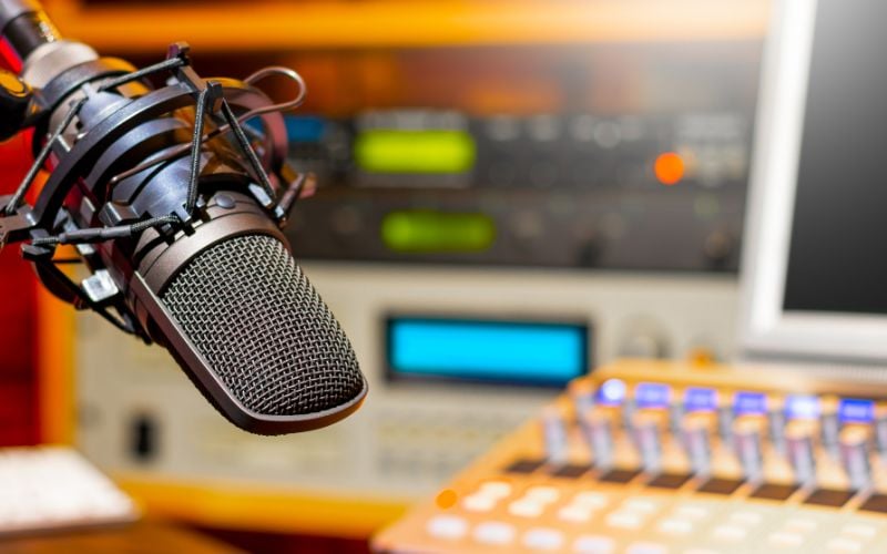 Microphone in a radio studio with equipment in the background