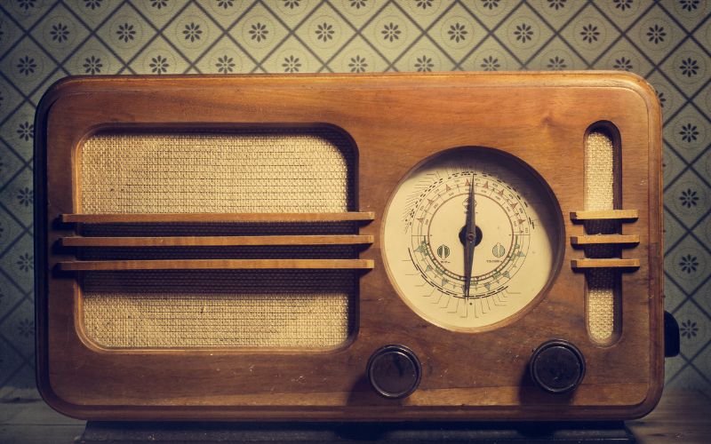 Vintage wooden radio against old wallpaper