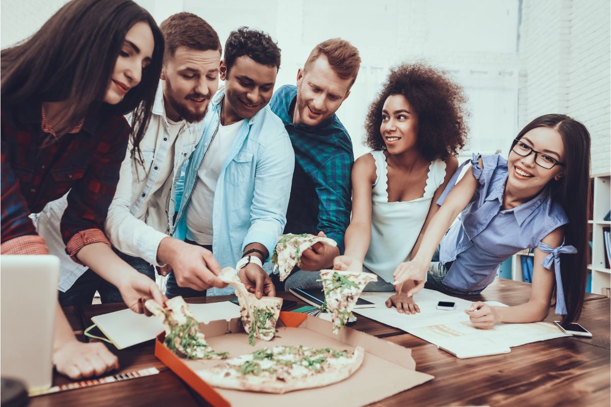 large-bright-office-group-eating-lunch-pizza