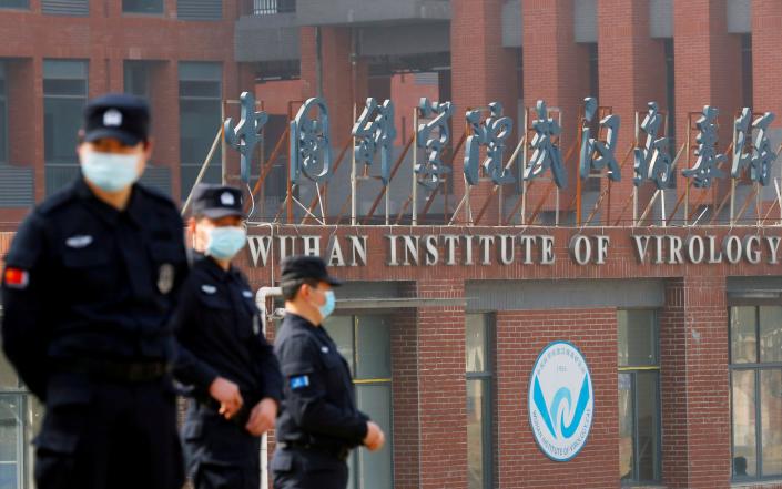 Security personnel stand guard outside the Wuhan Institute of Virology - THOMAS PETER