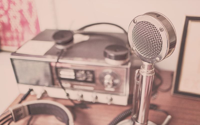 Silver Eton radio and silver microphone with pink overlay on a table with jazz radio stations