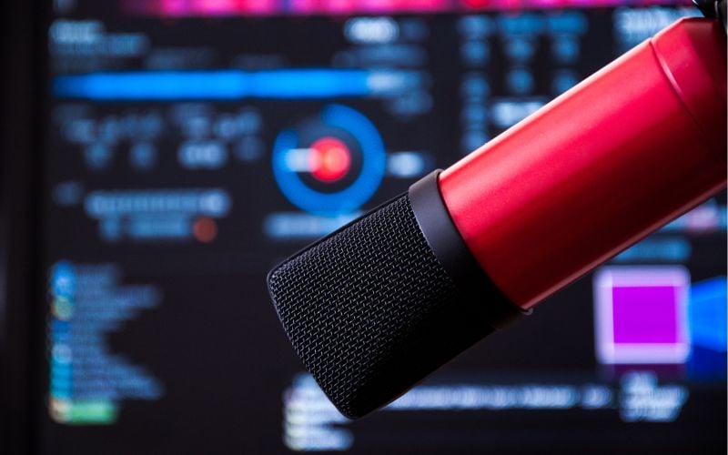 Bright red microphone in front of a blue radio screen 